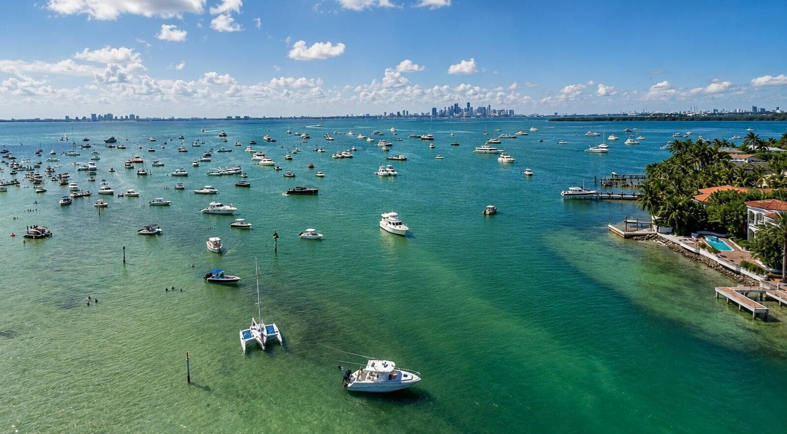 Aerial view of boats anchored at the Nixon Sandbar in Biscayne Bay, with the Miami skyline on the horizon